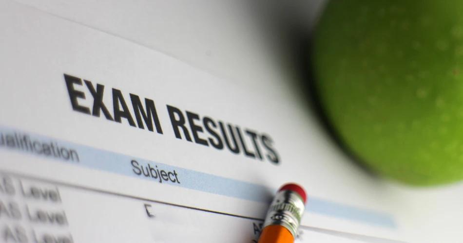 Close-up of an exam results sheet with a pencil and green apple, representing the announcement of MHT CET 2025 PCB results and student readiness for next admission steps.