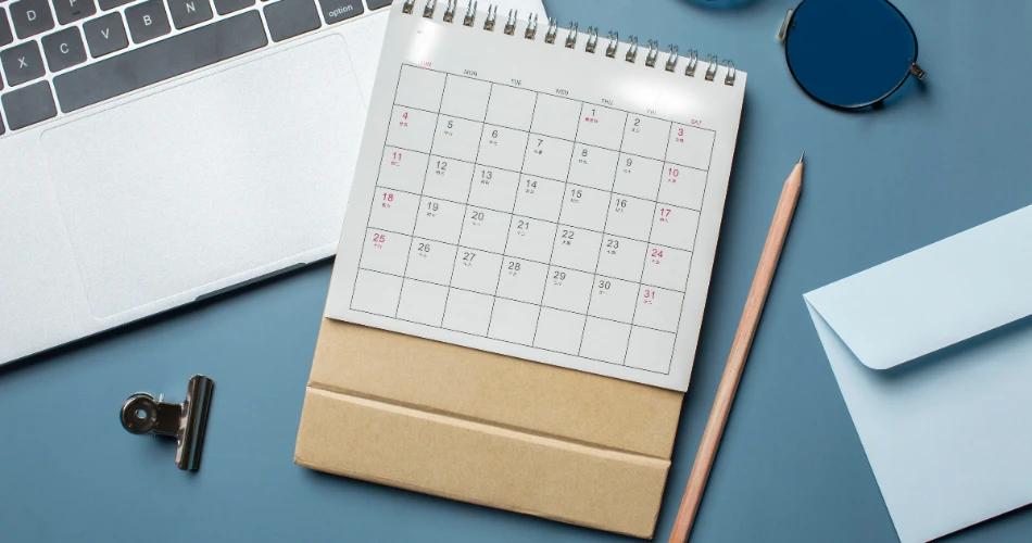 Calendar and laptop on desk for CUET UG 2025 admit card and exam dates news