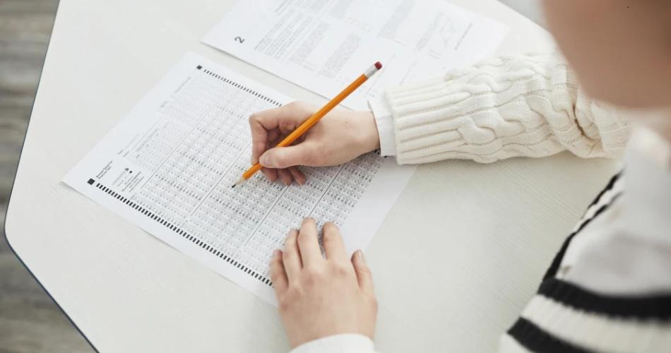 A student reviewing the NEET (UG) 2025 Final Answer Key with a pencil on paper.