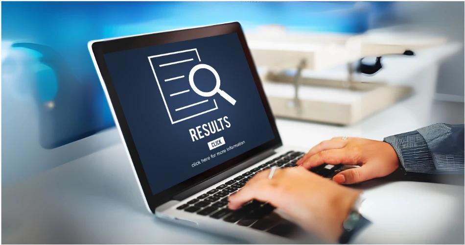 A student searching for CBSE Class 12 results on a laptop with an emphasis on exam results.