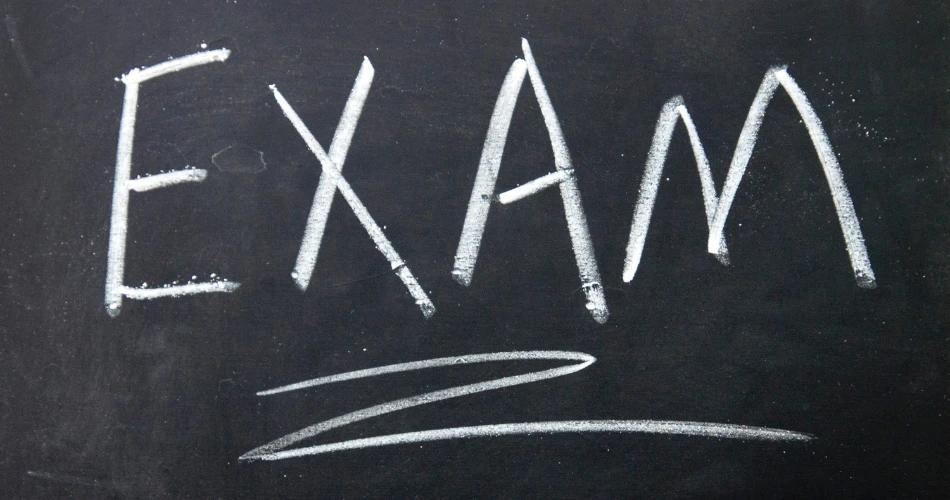 The word 'EXAM' written in large white chalk letters on a blackboard with a sweeping underlining signifying the MAH CET 2025 Additional Exam.