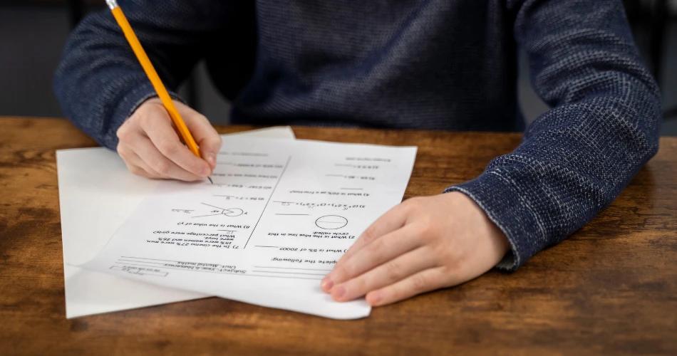 A student reviewing their answer sheet with a pencil, possibly preparing for revaluation of their Maharashtra SSC 2025 results
