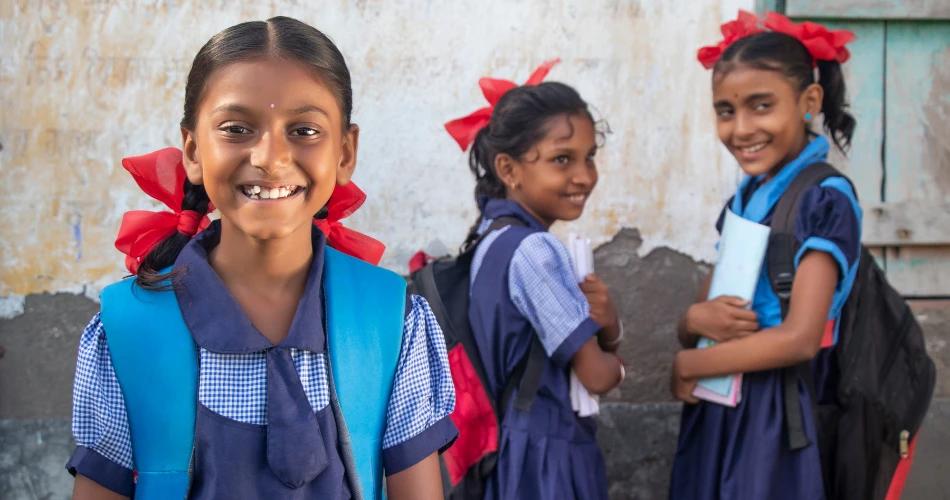 Group of school children in uniform, with red ribbons in their hair, representing students learning Hindi as a mandatory third language in Maharashtra schools