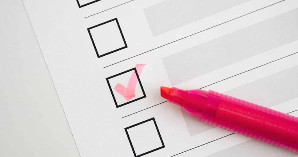 Close-up image of a checklist form with a pink marker placed beside a checked box, symbolizing the process of submitting or addressing objections